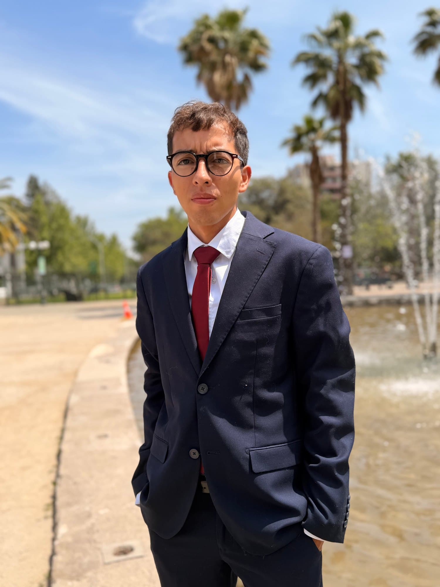 Integrante del equipo de Abogrado, de terno azul y corbata roja, junto a una pileta