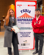 Dos personas junto al letrero de la Feria Expogrado